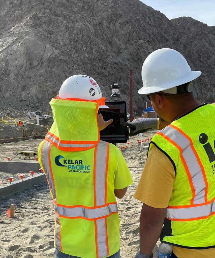 Kelar Pacific training subcontractor on robotic total station field layout - two people using the BIM data via ipad and prism.